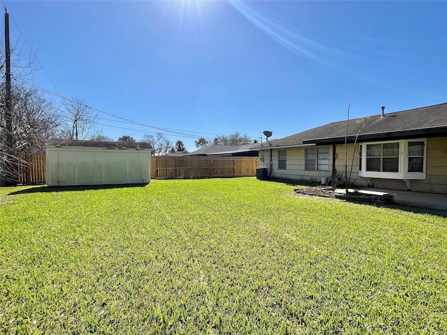 view of yard with a patio, an outbuilding, and fence