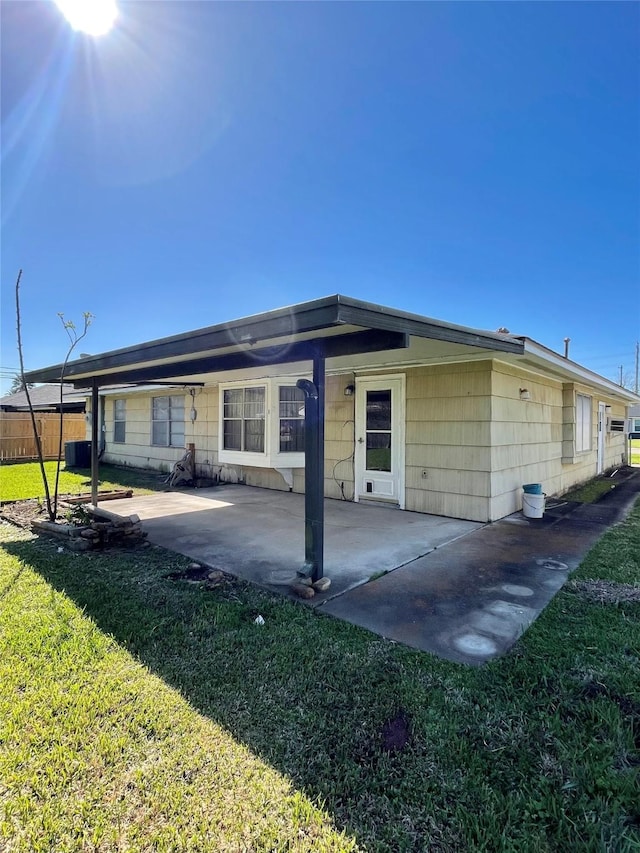 back of property featuring a patio area and a yard