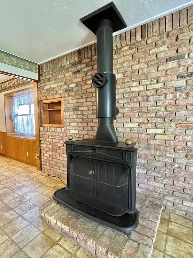 room details featuring wooden walls, a textured ceiling, and a wood stove