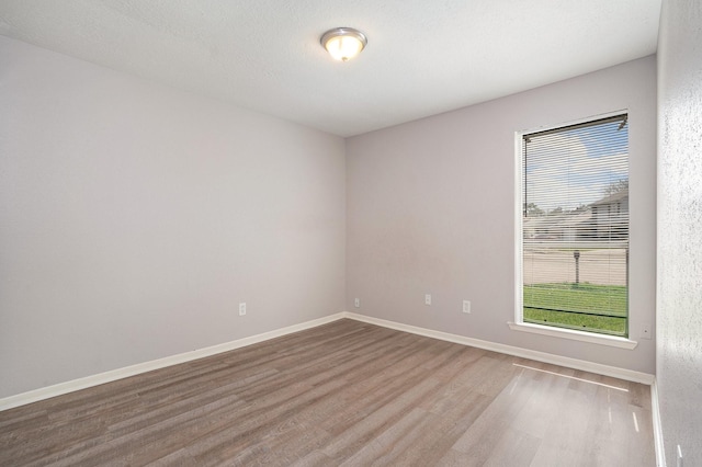 empty room with baseboards and wood finished floors