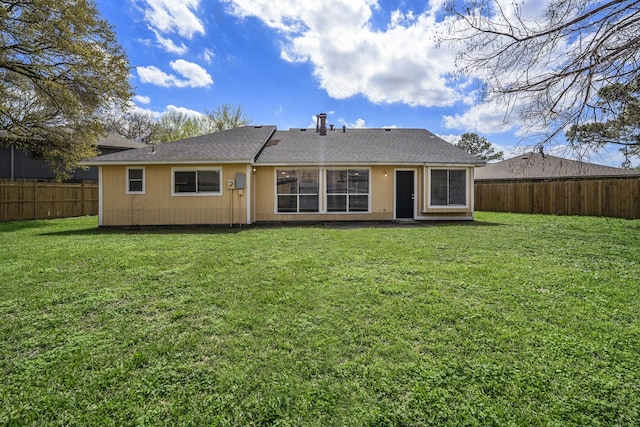 back of property with a fenced backyard and a lawn