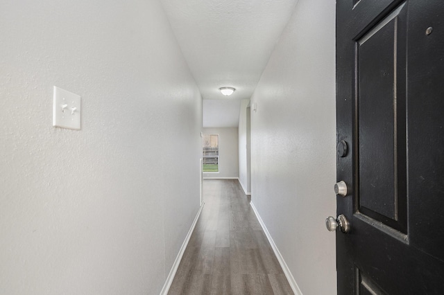 hall featuring wood finished floors and baseboards