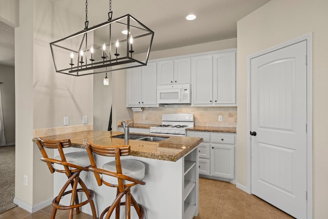 kitchen featuring a sink, white appliances, and white cabinetry