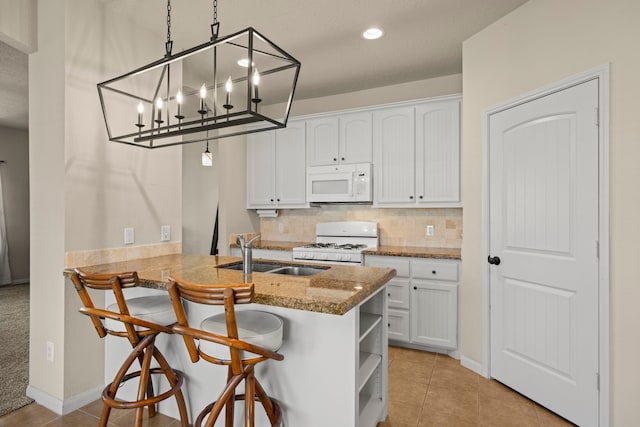 14864 Cetus Ct, Willis, TX 77318 - kitchen featuring white appliances, a sink, white cabinets, and recessed lighting