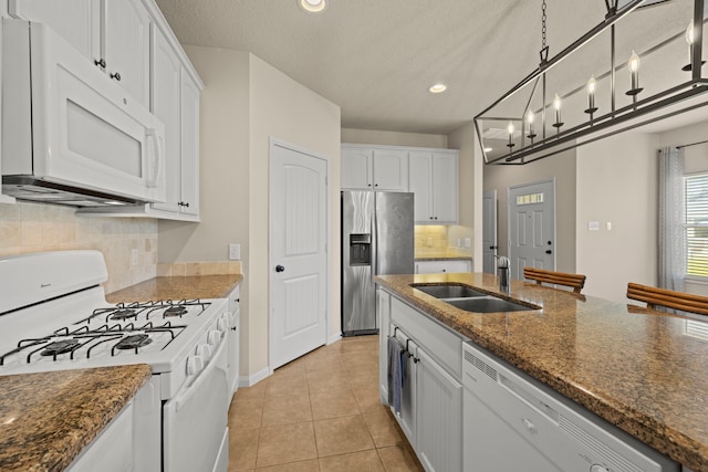 kitchen featuring light tile patterned flooring, white cabinets, white appliances, and a sink