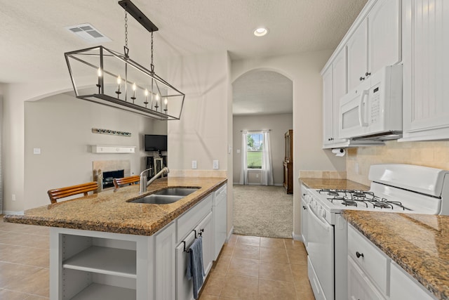 kitchen with white appliances, visible vents, arched walkways, a sink, and white cabinetry