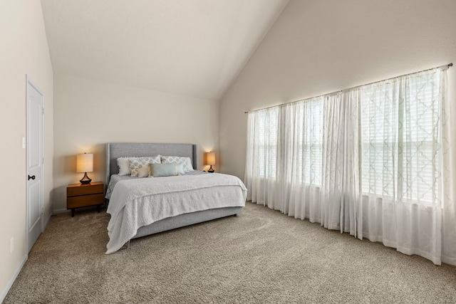 bedroom featuring carpet flooring, multiple windows, and high vaulted ceiling