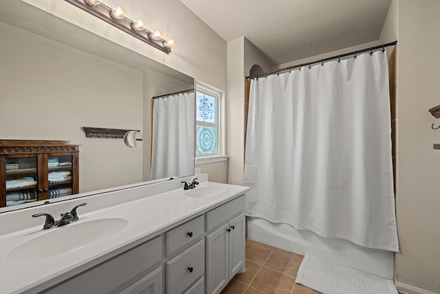 14864 Cetus Ct, Willis, TX 77318 - bathroom featuring double vanity, tile patterned flooring, a textured ceiling, and shower / bath combo with shower curtain