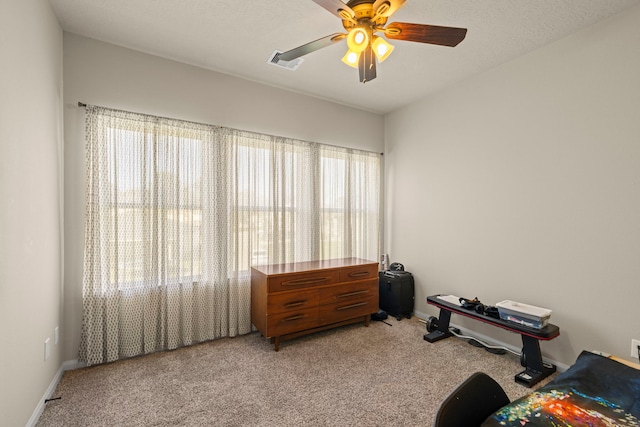 misc room with visible vents, light colored carpet, baseboards, and a ceiling fan