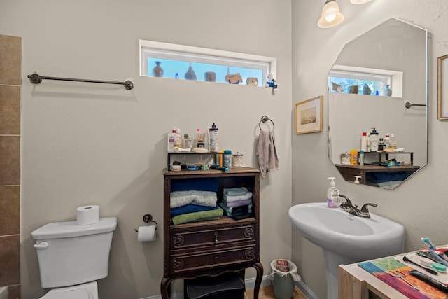 bathroom with toilet and baseboards