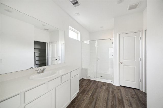 bathroom with visible vents, a shower stall, vanity, and wood finished floors