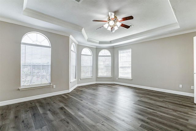 spare room with wood finished floors, baseboards, a raised ceiling, and ceiling fan