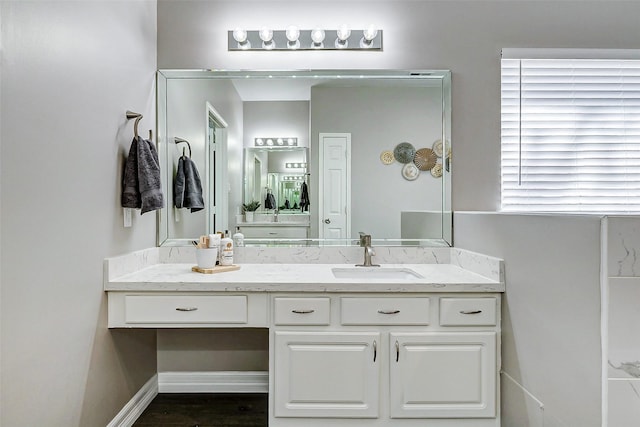 bathroom with vanity, baseboards, and wood finished floors