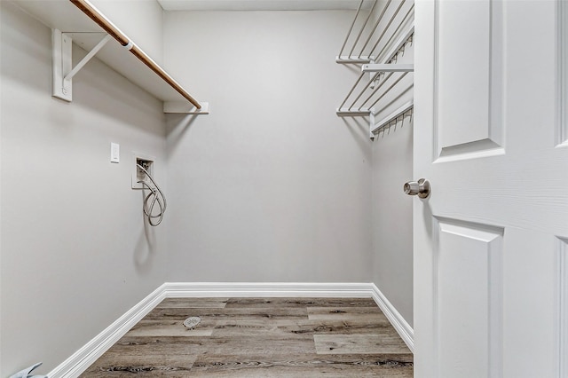 washroom with washer hookup, laundry area, wood finished floors, and baseboards