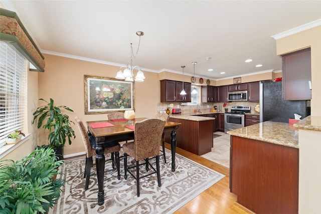 dining room with a chandelier, recessed lighting, light wood-style floors, and ornamental molding