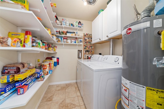 clothes washing area featuring baseboards, washing machine and clothes dryer, light tile patterned flooring, cabinet space, and water heater