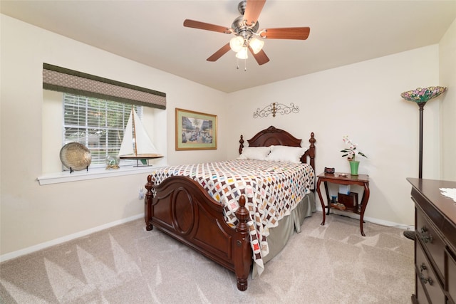 bedroom with a ceiling fan, baseboards, and light carpet