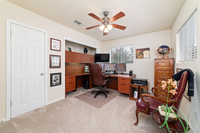 office space featuring visible vents, light colored carpet, and ceiling fan