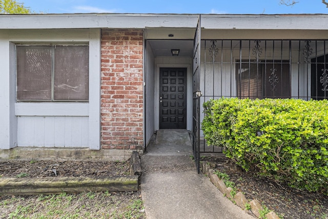 doorway to property featuring brick siding