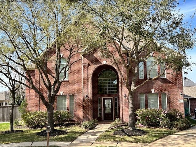 view of front of property with fence and brick siding