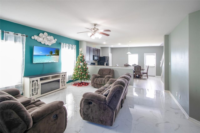 living area featuring recessed lighting, baseboards, marble finish floor, and ceiling fan