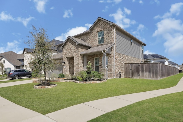 view of front facade with driveway, a front lawn, fence, a residential view, and brick siding