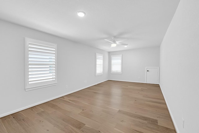 empty room featuring wood finished floors, a ceiling fan, and baseboards