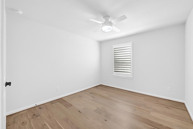 empty room featuring a ceiling fan, wood finished floors, and baseboards