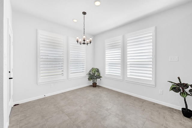 unfurnished dining area with a chandelier, recessed lighting, and baseboards