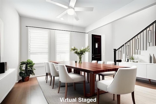 dining room with stairway, light wood-type flooring, and a ceiling fan