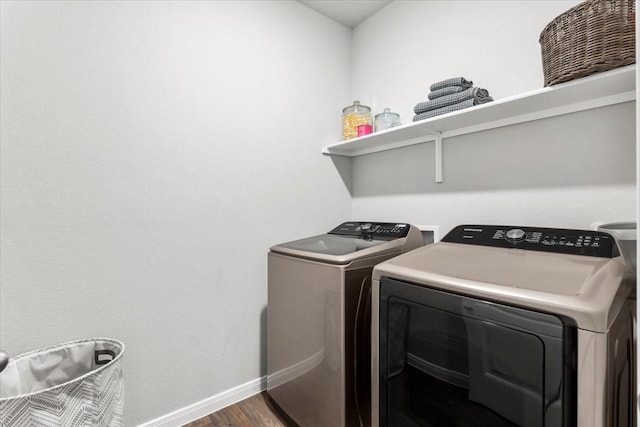 washroom featuring laundry area, separate washer and dryer, baseboards, and dark wood-style flooring