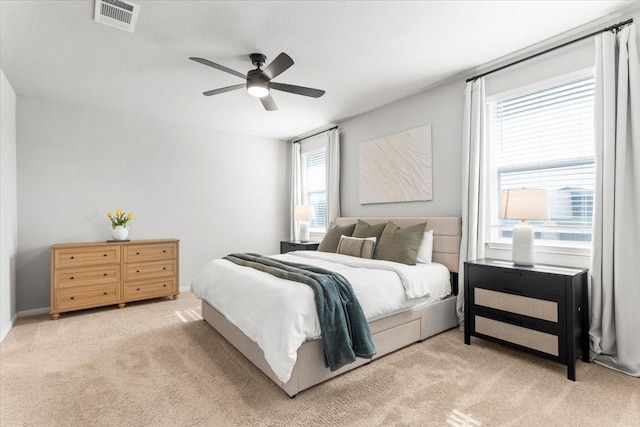 bedroom with light carpet, visible vents, and ceiling fan