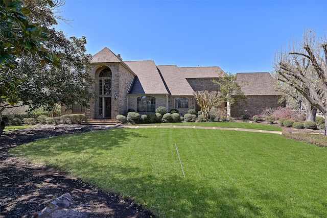 view of front of property with a front yard and brick siding