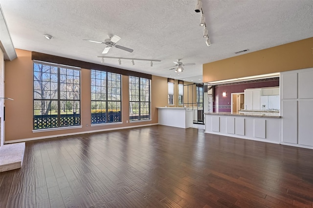 unfurnished living room with dark wood-style floors, visible vents, a textured ceiling, and ceiling fan