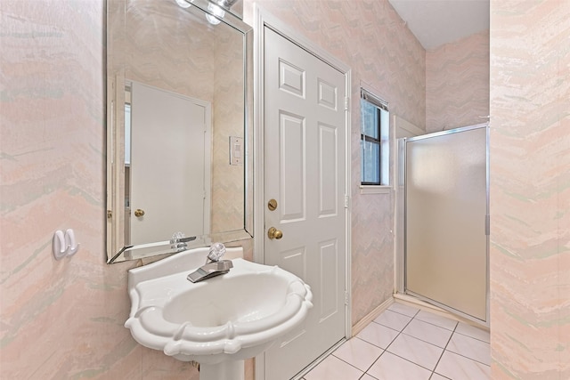 bathroom featuring wallpapered walls, tile patterned floors, a stall shower, and a sink