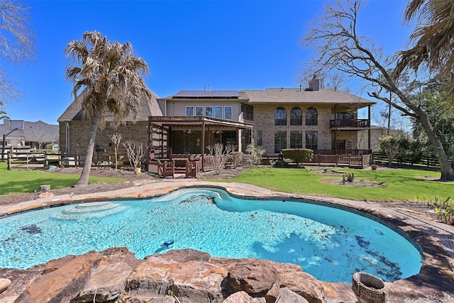 pool with a patio area, a lawn, and fence