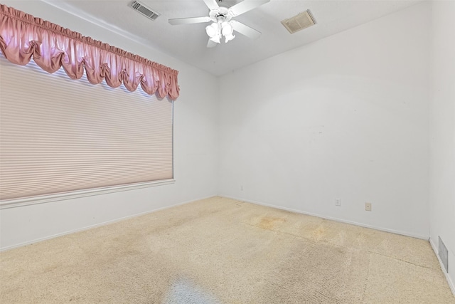 unfurnished room with visible vents, carpet flooring, baseboards, and a ceiling fan