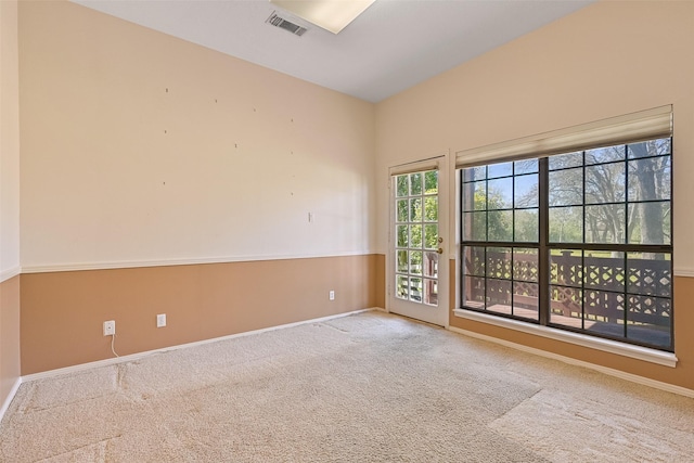 carpeted empty room with visible vents and baseboards