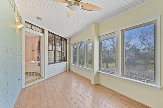 unfurnished sunroom with visible vents and a ceiling fan