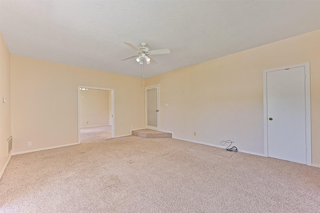 empty room with a ceiling fan, baseboards, carpet floors, and a textured ceiling