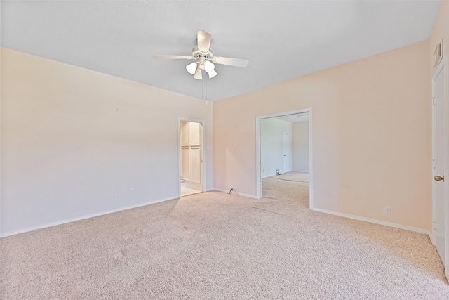 spare room with light colored carpet, baseboards, and ceiling fan