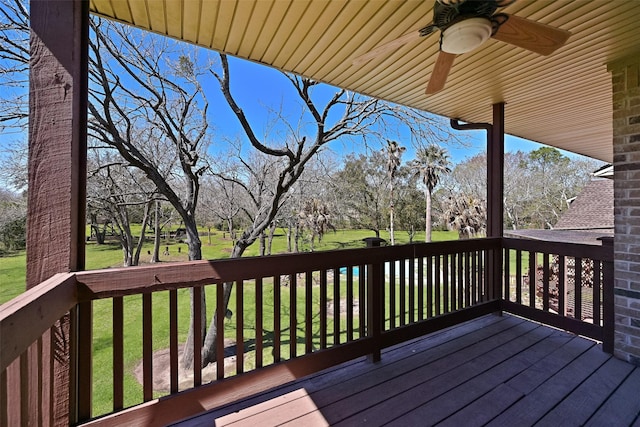 wooden deck with a ceiling fan and a lawn