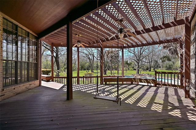 wooden deck featuring a pool, a ceiling fan, and a pergola