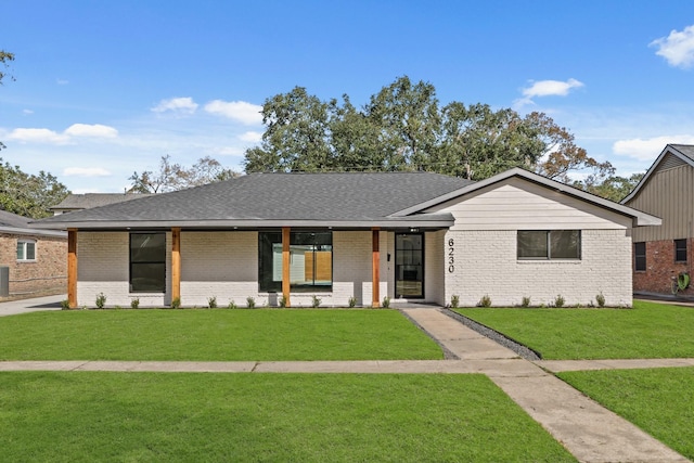 mid-century inspired home featuring a front lawn, brick siding, and roof with shingles