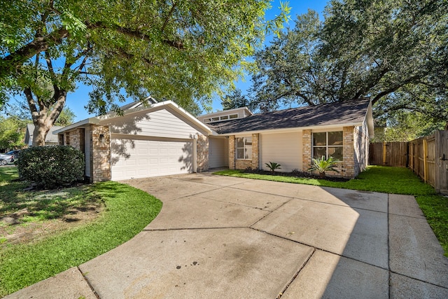 view of front of home featuring a front lawn, fence, concrete driveway, a garage, and brick siding