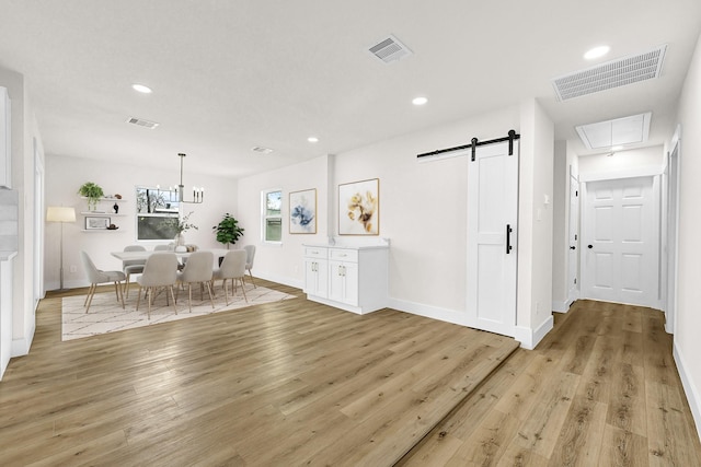 kitchen featuring light wood-type flooring, visible vents, a barn door, and recessed lighting