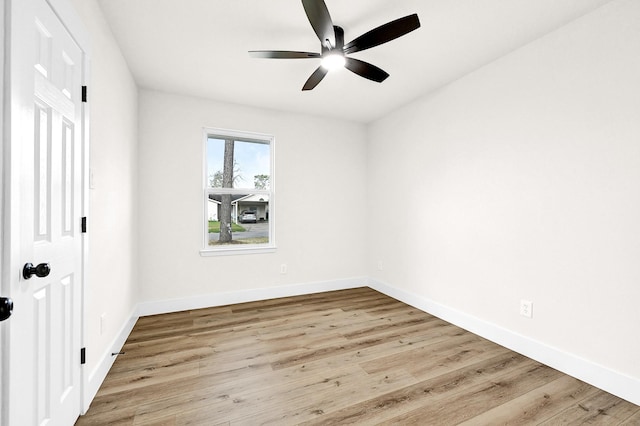 empty room featuring wood finished floors, baseboards, and ceiling fan