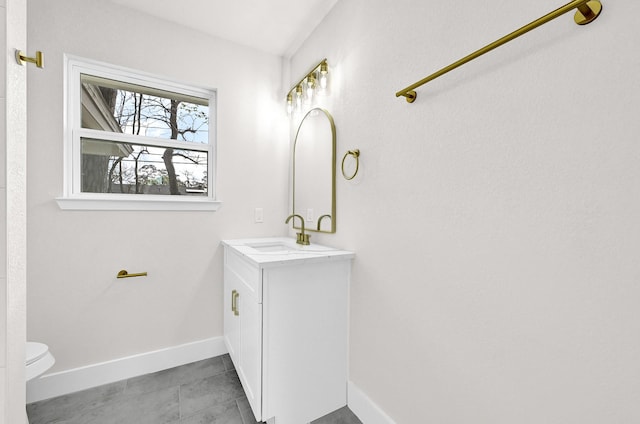 bathroom featuring vanity, toilet, baseboards, and tile patterned flooring