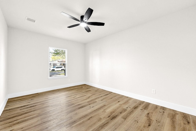 empty room with wood finished floors, baseboards, and ceiling fan