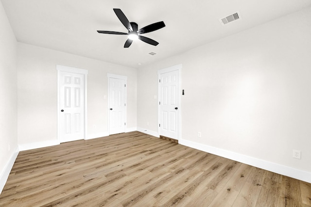 unfurnished bedroom with visible vents, baseboards, wood finished floors, and a ceiling fan